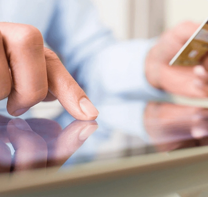 A person is using their cell phone on the table.